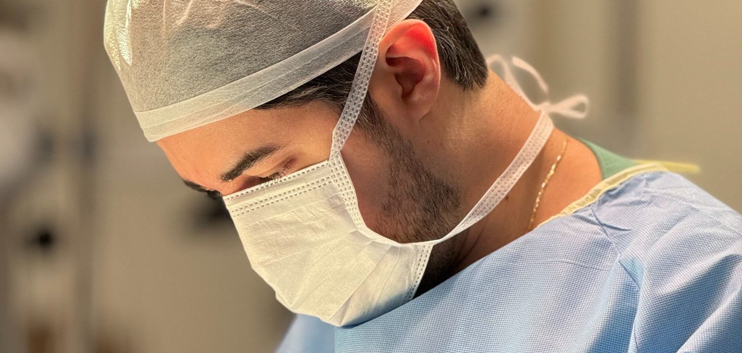 Dr. Fernando Freitas operando no centro cirúrgico, em ambiente hospitalar